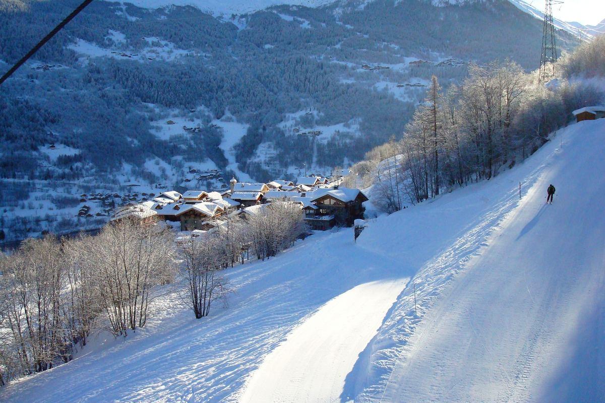 Skier skiing towards villaroger town ski resort